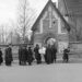 Svartvit bild från 1940-talet. Ett begravningståg är på väg in i kyrkan.